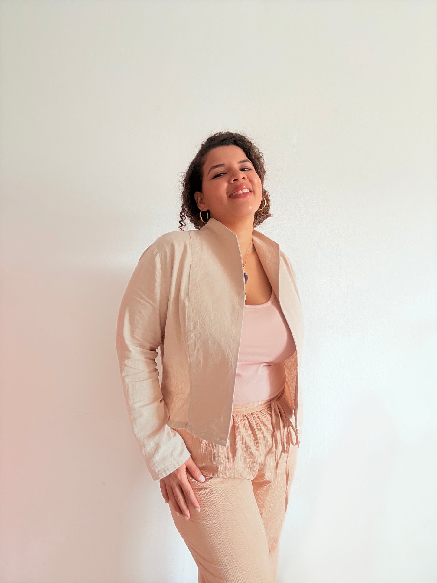 Woman wearing a beige jacket and pants against a white background