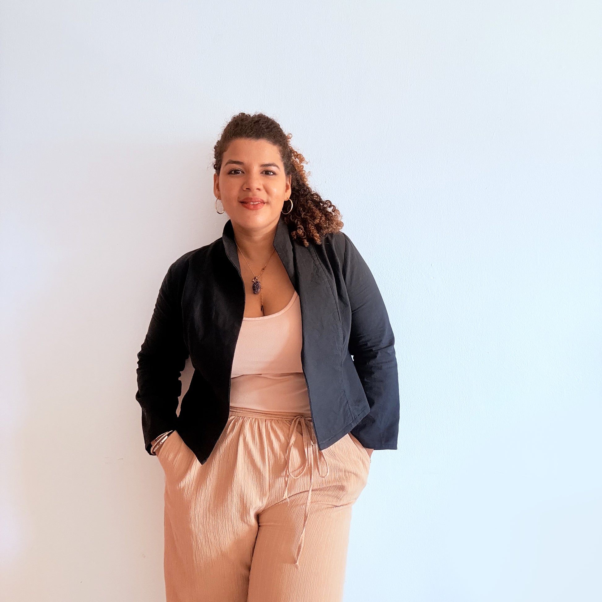 Woman wearing a black jacket unlined and beige pants 