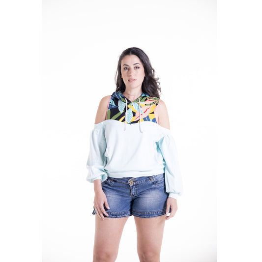 Woman wearing a colorful hoodie and denim shorts on a white background