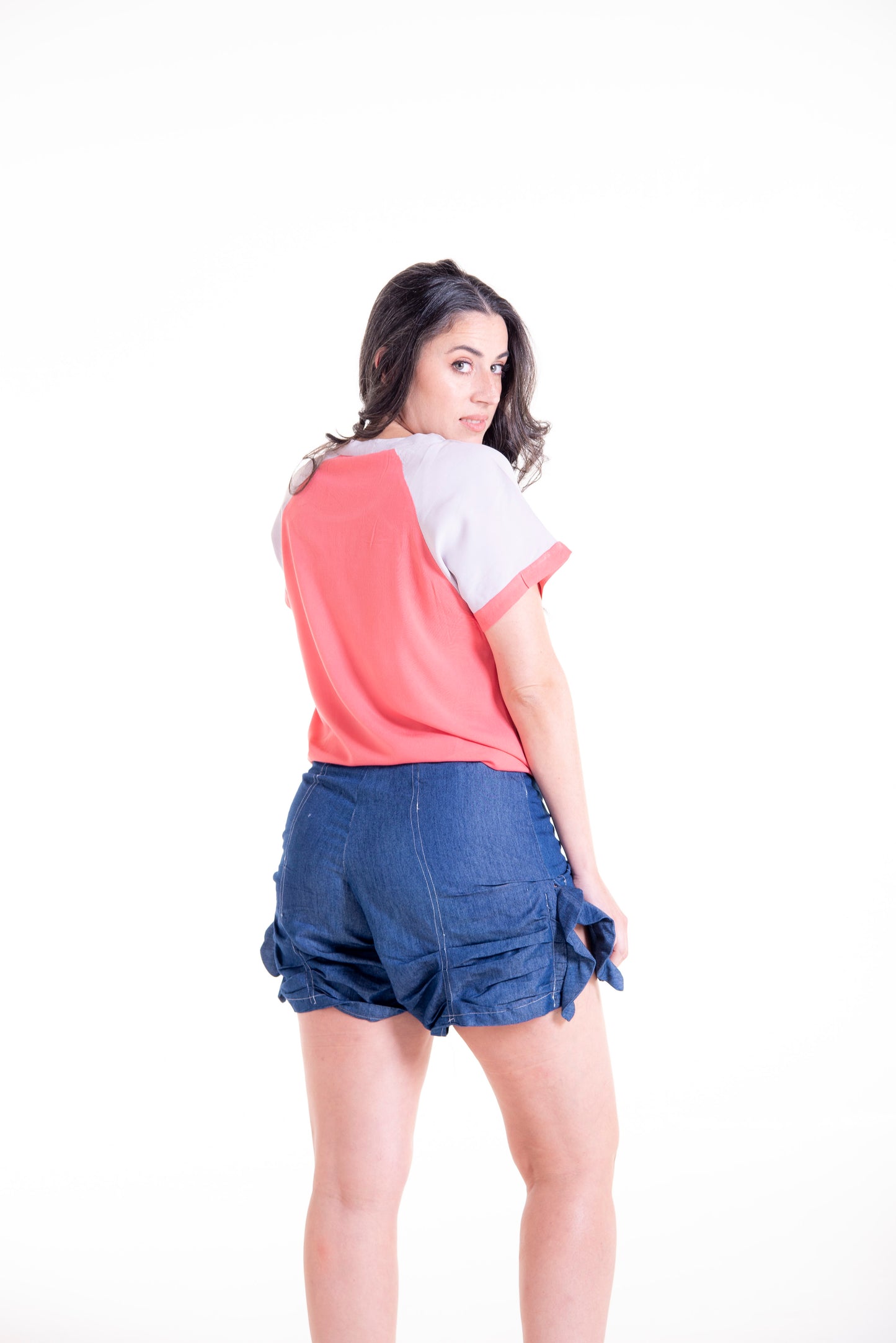 Side view of coral Willow raglan shirt with denim shorts - casual outfit styling